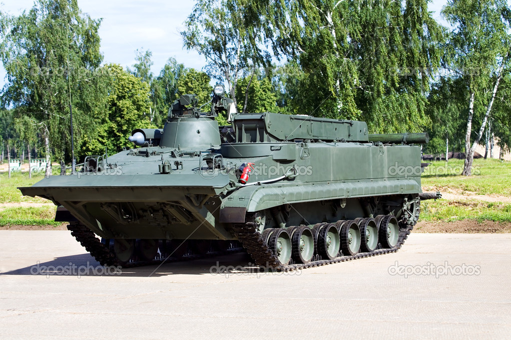 Militärisches Bergefahrzeug mit Kran neben einem beschädigten Panzer
